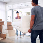 Couple moving sofa using deadlifts and deadshifts